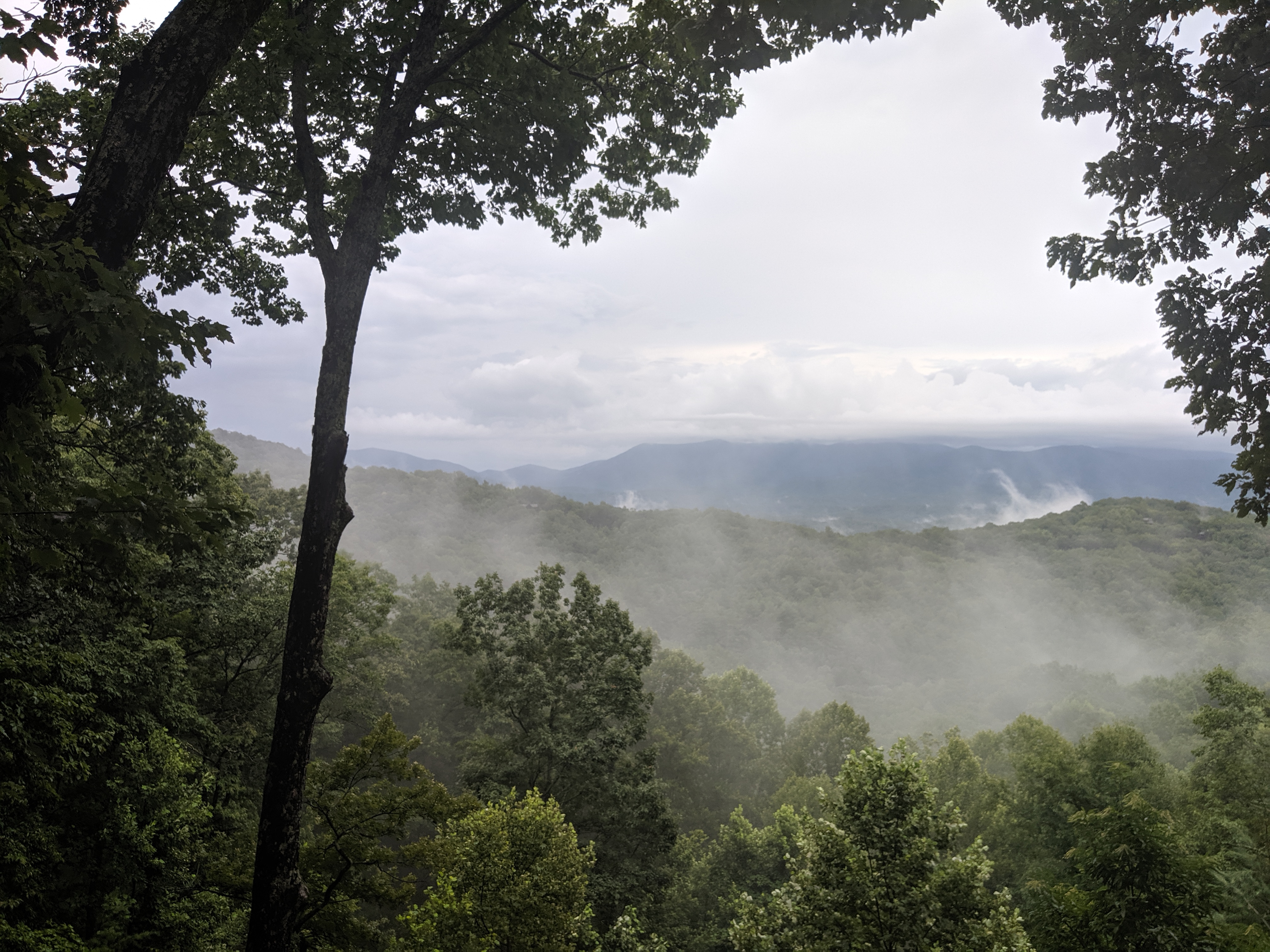 Fog and mist drifting across the valley below the cabin.